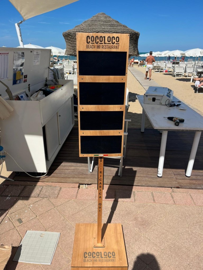 Colonnina ENERGY2GO con il logo inciso del Cocoloco Beach and Restaurant di Fano, sulla passerella della spiaggia